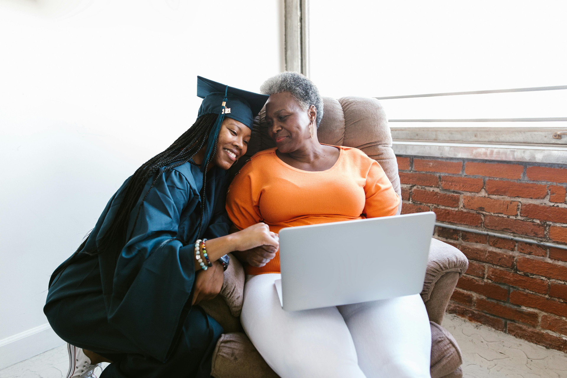 Graduate daughter sharing a laptop moment with her mother